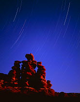 Hoodoo formations of heavily banded sandstone at night with star trails, Navajo Reservation, Arizona, USA
