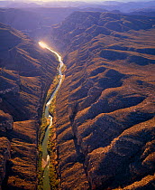 Aerial view of Rio Grande passing through the Boquillas Canyon with the Chisos Mountains and Big Bend National Park in the background, Texas, USA on right of river, Mexico on left of river.