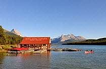 People canoeing on Maligne Lake by boat house, Jasper National Park, Rocky Mountains, Alberta, Canada, September 2009