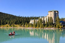 Two people canoeing on Lake Louise, a hotel on the shore, Banff National Park, Rocky Mountains, Alberta, Canada, September 2009
