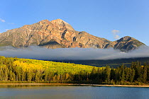 Pyramid Mountain towering above Pyramid Lake with low clouds over forest, Jasper National Park, Rocky Mountains, Alberta, Canada, September 2009