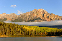 Pyramid Mountain towering over Pyramid Lake with low clouds over forest, Jasper National Park, Rocky Mountains, Alberta, Canada, September 2009