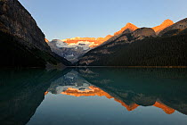 Lake Louise at sunrise with moutains reflected in water, Banff National Park, Rocky Mountains, Alberta, Canada, September 2009