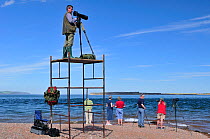 Laurie Campbell photographing Bottlenosed dolphins (Tursiops truncatus) from scaffold tower for Wild Wonders of Europe project, Moray Firth, Nr Inverness, Scotland, May 2009