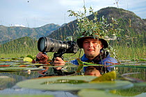 Photographer, Milan Radisics, submerged and camouflaged, in water of Lake Skadar, Lake Skadar National Park, Montenegro, May 2008, on location for Wild Wonders of Europe  WWE BOOK PLATE. WWE OUTDOOR E...