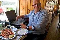 Photographer, Angelo Gandolfi, at his computer on assignment in Galicia, Spain. July 2008.