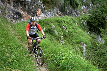 Man mountain biking in Desfiladero gorge, de Les Xanes, Somiedo Natural Reserve, Asturias, Spain. July 2008.