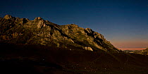 Aliva valley at 4am, Picos de Europa National Park, Cantabria, Spain. The mountain is illuminated by moonlight, and in the background is the first light of dawn. July 2008.