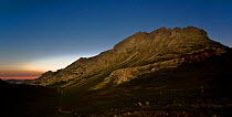 Aliva valley at 4am, Picos de Europa National Park, Cantabria, Spain. The mountain is illuminated by moonlight, and in the background is the first light of dawn. July 2008.