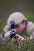 Deer stalker looking down his gun, Glenfeshie, Cairngorms NP, Scotland, UK, June 2008, model released