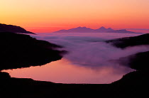 Rum and Eigg from Ardnamurchan Peninsula with incoming sea fog at sunset, Scotland, May