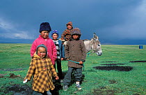 Children from the high plateaus of Kyrgyzstan with a thunder storm brewing in the background, Kyrgyzstan, central Asia, July 2003