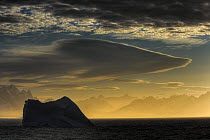 Silhouette of iceberg with lenticular clouds in morning mist, South Georgia (non-ex)