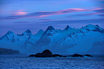 Lenticularis clouds forming at sunset over mountains, King Haakon Bay, South Georgia, December 2006