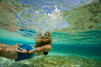 Woman swimming underwater, Exumas, Bahamas. February 2007. Model released.