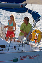 Couple sailing a Sunsail Oceanis 423 yacht in the BVI's, March 2006. Model and property released.