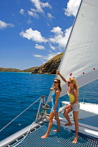 Women on the trampoline of a Sunsail Lagoon 410 in the BVI, April 2006. Model and property released.