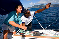 Sunsail team instructor teaching a man how to sail aboard a Sunsail Oceanis 393 in the BVI. April 2006, Model and property released.