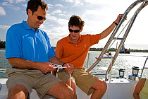 Father teaching his son how to tie a knot aboard a Hunter 49 yacht off St. Augustine, Florida, USA. Model and Property released, 2006.