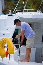 Man emptying a bucket of water from a yacht in the British Virgin Islands, March 2006.