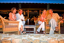 Two couples relaxing at a bar in the British Virgin Islands, March 2006. Model released.