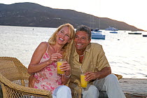 Couple relaxing at a waterside bar in the British Virgin Islands, March 2006. Model released.