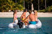 Friends in a tender approaching a beach in the British Virgin Islands, March 2006. Model and property released.