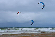 Kite surfers riding waves near the shore at Rhossili Bay, The Gower Peninsula, Wales, August 2009