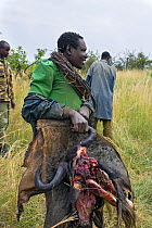 Apprehended poachers assisting Mara Conservancy rangers in burning their supplies and meat, Serengeti National Park, Tanzania, August 2006