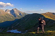 Photographer, Bruno D'Amicis, walking on a ridge, Western Tatras, with Mount Krivn (2,495m) in the background, Western Tatras, Carpathian Mountains, Slovakia, June 2009