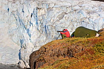 Photographer, Kai Jensen, sitting outside tent photographing, by the Russells glacier, Greenland, August 2009