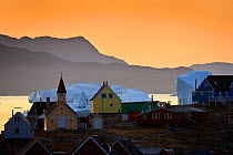 Houses and church in Saqqaq with icebergs on the sea, at sunrise, Disko Bay, Greenland, August 2009