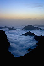 Moutains surrounded by low lying clouds, viewed from Pico do Arieiro, at dusk, Madeira, March 2009