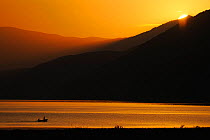 Fishermen on Lake Prespa at sunrise, Lake Prespa National Park, Albania, June 2009