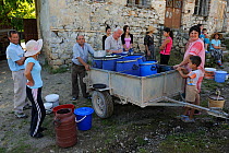 The milkman collecting milk from the farmers, Lesser Lake Prespa, Lake Prespa National Park, Albania, June 2009