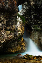 Waterfall flowing under hole in rock, River Moznica, Moznica valley, Triglav National Park, Slovenia, July 2009