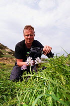 Peter Lilja photographing a Naked man orchid (Orchis italica) in flower, Kayalar, Northern Cyprus, April 2009