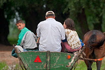 Farming family in traditional horse drawn cart, near Lake Belau, Lake Belau, Moldova, June 2009