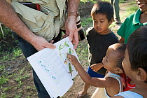 Tim Appleton showing children bird illustrations in a field guide, Narra, Palawan, Philippines, March 2009