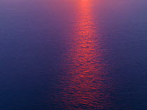 Sun reflected in sea at sunset, viewed from the Cliffs of Moher, County Clare, Republic of Ireland, June 2009