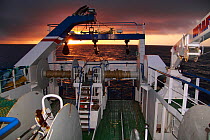 Looking aft onto the trawl deck of a fishing vessel at dusk, December 2009, North Sea.