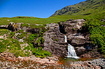 Man swimming in mountain pool at foot of waterfall, Glen Coe, Scotland, June 2009