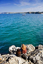Mother and daughter fishing off Newquay Old Harbour, Cornwall. September 2009.