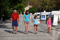 Family walking alongside boats, Canal Du Midi near Carcassonne, Languedoc, France. July 2009. Model and property released.