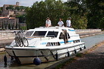 Friends cruising on the Canal Du Midi near Capestang, Languedoc, France. July 2009. Model and property released.