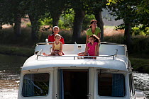 Family cruising on the Canal Du Midi near Aiguille, southern France. July 2009. Model and property released.