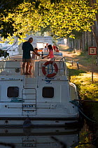 Family cruising on the Canal Du Midi near Port de Bram, southern France. July 2009. Model and property released.