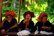 Padaung women eating, in Indein, Shan State, Myanmar, Burma. August 2009