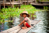 Young boy with a hat, in a traditional boats, Inle Lake, Shan State, Myanmar, Burma. August 2009