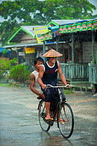 Cyclist under a heavy rain, Nyaungshwe, Shan State, Myanmar, Burma. August 2009